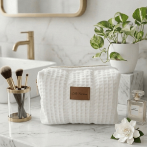 Χειροποίητο μεσαίο νεσεσέρ καλλυντικών Little Moments από την Rêve Skincare. Premium waffle ύφανση σε λευκό χρώμα με χρυσό φερμουάρ και δερμάτινη λεπτομέρεια.